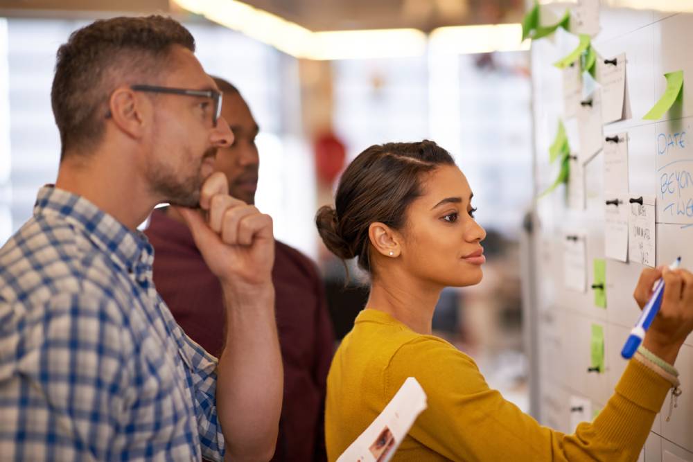 Un equipo de trabajo colabora e intercambia ideas durante una sesión de brainstorming. La colaboración, la comunicación y el pensamiento crítico son habilidades blandas esenciales para el futuro laboral.